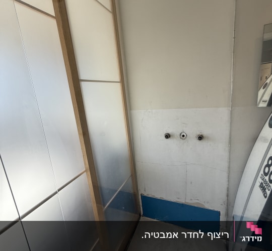 חדר אמבטיה עם דלתות זכוכית ומקלחת